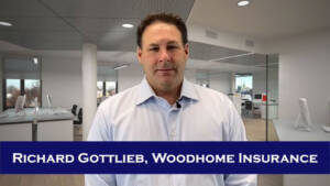 A man in a blue shirt is standing in an office.